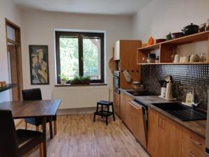 a kitchen with wooden cabinets and a table and a window at Hidden Gem Villa & Gated Parking in Český Krumlov