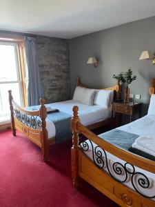 a bedroom with two beds and a window at The Ormond Apartments in Dungarvan