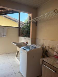 a kitchen with a washing machine in the middle of a room at Espaço vovô Wilson in Joinville