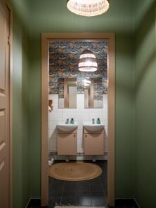 a bathroom with two sinks and two mirrors at Marinans Guesthouse in Nävekvarn