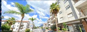 a city street with palm trees in front of buildings at Mira Beach Casa Vacanze in Praia a Mare