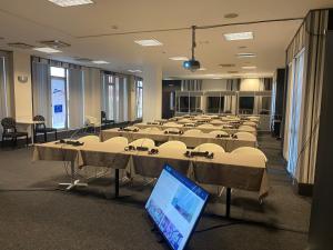 a room filled with tables and chairs with a laptop at Hotel Paradis in Cluj-Napoca