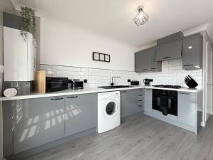 a kitchen with a washing machine and a washer at Bathgate Penthouse near Edinburgh in Bathgate