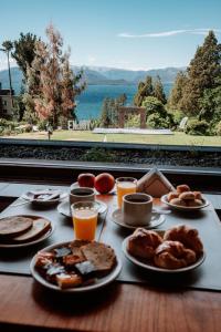 a table topped with plates of breakfast foods and orange juice at Basia Hotel & Sushi in San Carlos de Bariloche