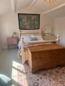 a bedroom with a large bed with a wooden foot board at Rose Cottage in Galway