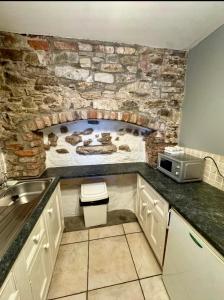 a kitchen with a stone wall with a stove at The Ormond Apartments in Dungarvan
