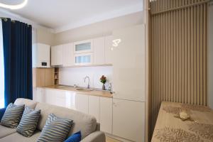 a living room with a couch and a kitchen at ASTI Residence Aparthotel in Năvodari