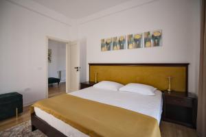 a bedroom with a large bed with a wooden headboard at ASTI Residence Aparthotel in Năvodari