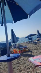 a group of chairs and umbrellas on a beach at Perla del mare Ionio in Fondachello