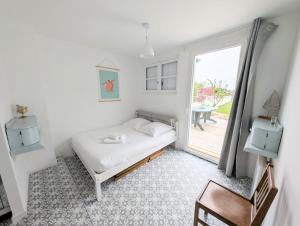 a small bedroom with a bed and a window at Superbe maison 85m2 - Plages à 2km - Jardin clos - Maison Kaerell in Billiers