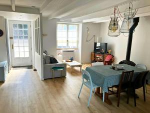 a living room with a table and a couch at Superbe maison 85m2 - Plages à 2km - Jardin clos - Maison Kaerell in Billiers