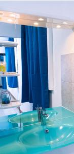 a bathroom with a blue sink and a mirror at Le Clos de Ébéniers in Saint-Laurent du Maroni