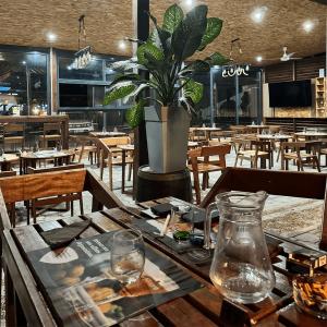 a restaurant with a table with a potted plant on it at Le Clos de Ébéniers in Saint-Laurent du Maroni