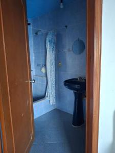 a blue bathroom with a sink and a tub at Casa Rosa in Tequesquitengo