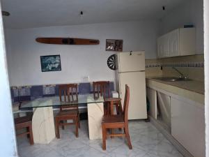 a kitchen with a table and chairs and a refrigerator at Casa Rosa in Tequesquitengo
