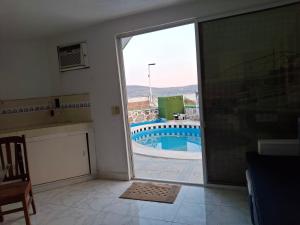 a living room with a view of a swimming pool through a sliding glass door at Casa Rosa in Tequesquitengo