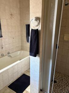 a bathroom with a bath tub and a sink at Cloete Self Catering Sky Room in Ermelo +1 photo