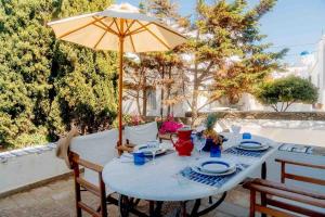 a table with an umbrella on a patio at Captain's Mansion Exampela in Apollonia