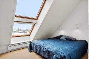 a bedroom with a blue bed and a large window at 1356-Thisted-Nordsovej-106 in Thisted