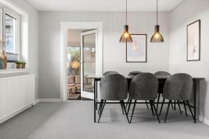 a dining room with a black table and chairs at 1375-Thisted-Nordsovej-15 in Nørre Vorupør