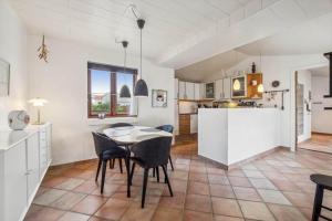 a kitchen and dining room with a table and chairs at 1075-Hanstholm-Badsgardsvej-25 in Hanstholm +17 photos