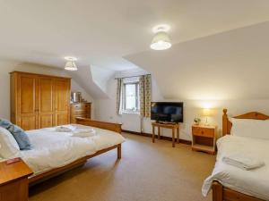 a bedroom with two beds and a flat screen tv at 3 Bed in Penrith oc-90990 in Pooley Bridge