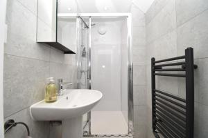 a white bathroom with a sink and a shower at 3 Bed in Penrith oc-90990 in Pooley Bridge