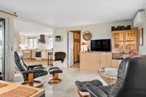 a living room with black leather chairs and a tv at 3392-Hvide-Sande-Fyrmarken-10 in Hvide Sande