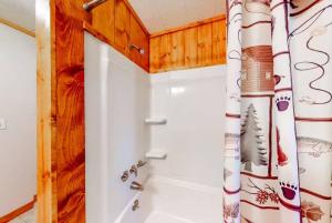 a bathroom with a shower with a shower curtain at Pine & Paddle in Saint Germain +28 photos