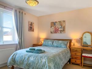 a bedroom with a bed with blue towels on it at Middle Cottage in Thirsk