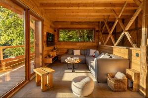 a living room of a wooden cabin with a couch at Chalet Les Cimes - Sauna - Jacuzzi in Gérardmer