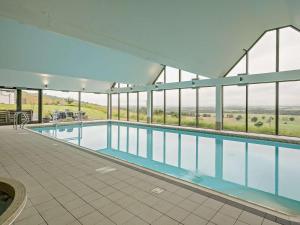 a large swimming pool in a building with windows at 2 Bed in Forfar oc-92621 in Aberlemno