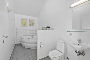 a white bathroom with a toilet and a sink at 749-Hvide-Sande-Slusen-49 in Hvide Sande +25 photos