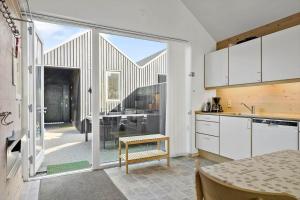 a kitchen with white cabinets and a large sliding glass door at 749-Hvide-Sande-Slusen-49 in Hvide Sande