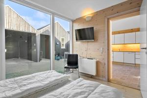 a bedroom with a bed and a tv on a wall at 749-Hvide-Sande-Slusen-49 in Hvide Sande
