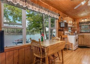 a kitchen with a table and a large window at Bayside - Bouchard Shores Resort in Minocqua