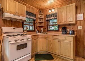 a kitchen with wooden cabinets and a white stove top oven at Bayside - Bouchard Shores Resort in Minocqua +13 photos