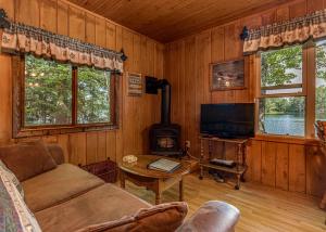 a living room with a couch and a tv and a stove at Bayside - Bouchard Shores Resort in Minocqua