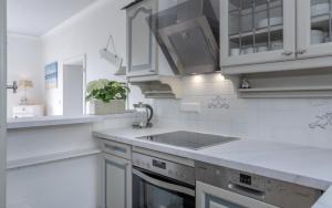 a white kitchen with a sink and a stove at Ferienhaus Weitblick in Morsum