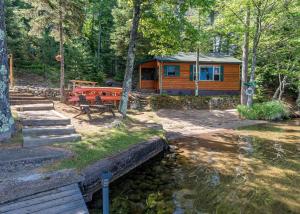 a cabin in the woods next to a stream at Bayside - Bouchard Shores Resort in Minocqua