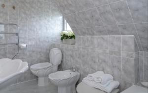 a white bathroom with a toilet and a sink at Ferienhaus Weitblick in Morsum