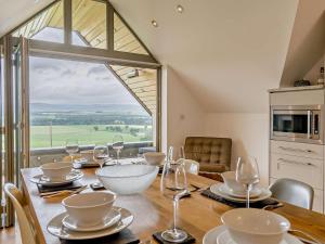 a dining room with a table with wine glasses at 2 Bed in Forfar oc-92623 in Aberlemno