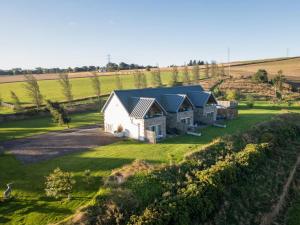 an aerial view of a white barn in a field at 2 Bed in Forfar oc-92623 in Aberlemno