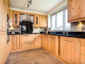 a kitchen with wooden cabinets and black counter tops at 3 Bed in Penrith oc-sz299 in Pooley Bridge +8 photos