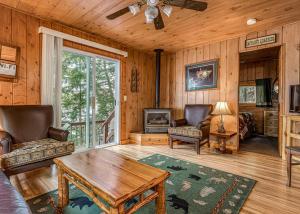 a living room with a ceiling fan and a table at Timbers - Bouchard Shores Resort in Minocqua