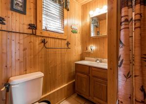 a wooden bathroom with a toilet and a sink at Timbers - Bouchard Shores Resort in Minocqua +5 photos