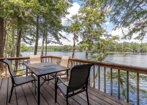 a table and chairs on a deck with a view of a lake at Timbers - Bouchard Shores Resort in Minocqua
