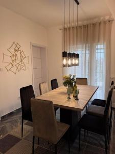 a dining room with a wooden table and chairs at Léda Vendégház in Vásárosnamény