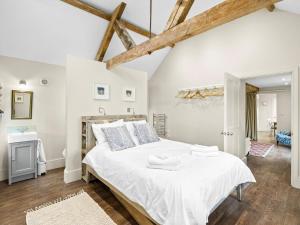 a bedroom with a large white bed with wooden beams at 2 Bed in Ludlow oc-83363 in Hopton Cangeford