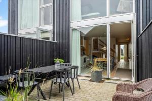 a patio with a table and chairs and a building at 733-Hvide-Sande-Slusen-33 in Hvide Sande
